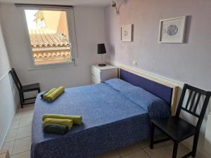 a bedroom with a blue bed and a window at Calaluna in La Maddalena
