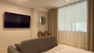 a living room with a large window with a flat screen tv at Ann Arbor Hotel in Ho Chi Minh City +28 photos