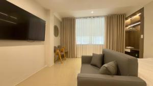 a living room with a couch and a flat screen tv at Ann Arbor Hotel in Ho Chi Minh City