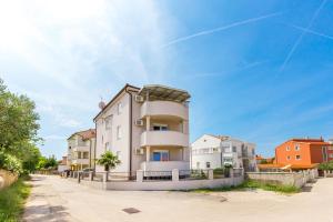 a large white building on a street at Apartments Tomo in Medulin