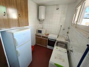 a small kitchen with a white refrigerator and a sink at Lamoga Ona in Torredembarra +123 photos