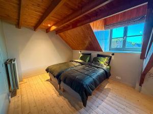 a bedroom with a large bed in a attic at Tussen Muur en Markt in Ieper