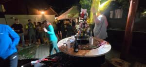 a crowd of people standing around a table with a cake at Pensiunea Gernik 100 in Gârnic +114 photos