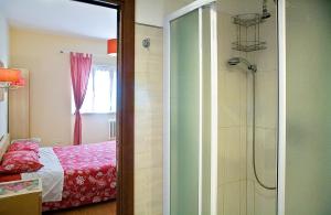 リド・ディ・オスティアにあるLa Dolce Sostaのバスルーム(ガラス張りのシャワー、ベッド付)