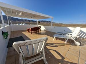 a patio with two chairs and a table on a roof at Dunas de Famara in Famara