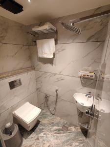 a bathroom with a toilet and a sink at Hotel Joy Guru Inn in Durgāpur +28 photos