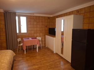 a small room with a table and a kitchen with a refrigerator at B&B Campisi Anna in Altamura