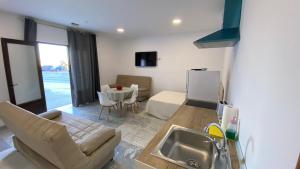 a kitchen and living room with a couch and a sink at 1 linea de playa - Apartamentos - Beach & River - Conil in Conil de la Frontera