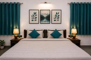 a bedroom with a large bed with blue curtains at Hotel Atithya in Udaipur