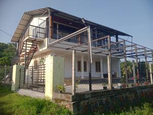 a house with a balcony on top of it at Mount View Attappadi in Agali