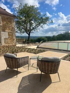 two chairs and a glass table on a patio at B&B Manoir Calmeer in Thenon