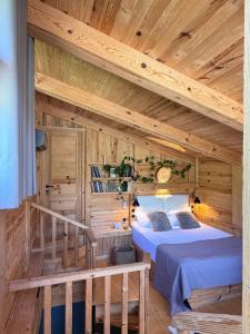 a log cabin bedroom with a bed and a staircase at Hotel Borjomi Verde in Borjomi
