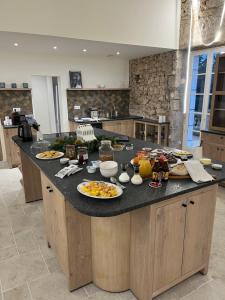 a kitchen counter with plates of food on it at B&B Manoir Calmeer in Thenon