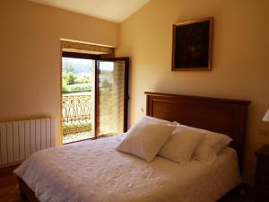 a bedroom with a bed and a window with a balcony at Casa da Poza in A Estrada