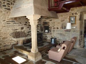a living room with a stone fireplace and a couch at Casa da Poza in A Estrada