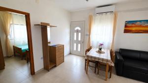 a living room with a table and a chair at Apartman Adriatic View in Vir +25 photos