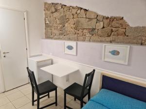 a room with a table and chairs and a bed at Calaluna in La Maddalena