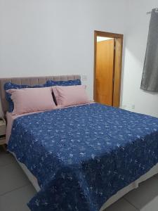 a bed with a blue comforter and a pink pillow at Dekatana Hotel Village in Helunmahara