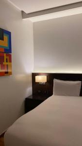 a bedroom with a bed and a nightstand with a white bedsheet at Dekatana Hotel Village in Helunmahara