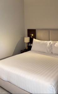 a large white bed in a room with a lamp at Dekatana Hotel Village in Helunmahara +3 photos