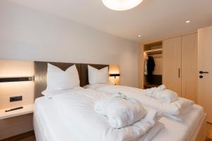 a bedroom with a large white bed with towels on it at Aparthotel Saladina in Gaschurn