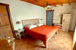 a bedroom with a bed with an orange bedspread at Clos de la Dîme in Lombers +12 photos