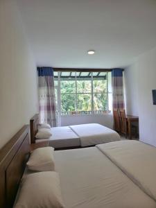 three beds in a room with a window at HILL SIDE RESORT - Ella in Ella +62 photos