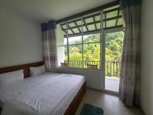 a bedroom with a bed and a large window at HILL SIDE RESORT - Ella in Ella