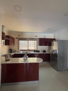 a kitchen with brown cabinets and a stainless steel refrigerator at JAYNIEL Apartments #2 in Lusaka