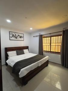 a bedroom with a large bed and a window at JAYNIEL Apartments #2 in Lusaka