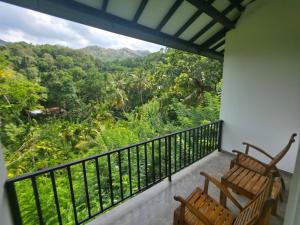 a balcony with two chairs and a view of the forest at HILL SIDE RESORT - Ella in Ella