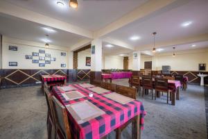 a restaurant with tables and chairs in a room at The Prakriti Hotel & Restaurant I Family Events I Sky Bonfire l Lift l Power Backup l Free Parking l Kufri By Exotic Stays in Kūfrī