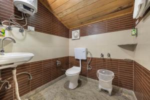 a bathroom with a toilet and a sink at The Prakriti Heights l Lift l Comfortable And Spacious Rooms l Free Wifi, Free Parking l Enjoy Fresh Mountain Air l Managed By Exotic stays in Shimla +19 photos