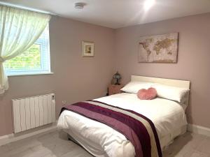 a bedroom with a bed with a pink stuffed animal on it at Ower Retreat in Ower