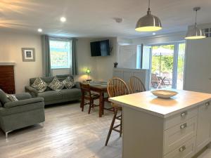 a kitchen and living room with a couch and a table at Ower Retreat in Ower
