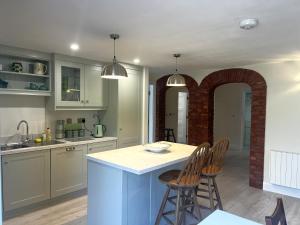 a kitchen with an archway and a table and chairs at Ower Retreat in Ower