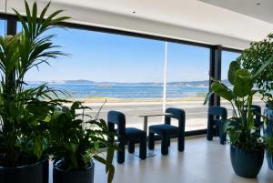 ein Zimmer mit Tisch und Stühlen und einem großen Fenster in der Unterkunft Hotel Delfin Azul in A Lanzada