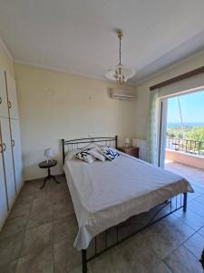 a bedroom with a bed and a large window at Pink House Eretria in Eretria +14 photos