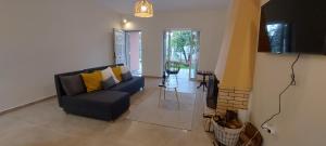 a living room with a blue couch and a table at Pink House Eretria in Eretria