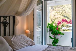 a bedroom with a bed and a window with a plant at Villa Areto in Kamares