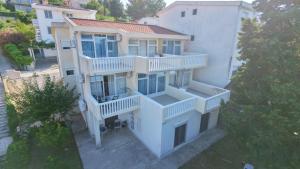 an aerial view of a white house with balconies at Joksimović apartmani in Šušanj