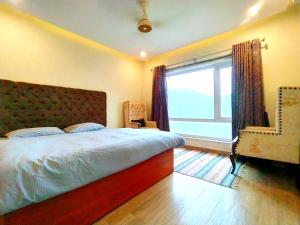 a bedroom with a bed and a large window at Luxe Villa in Murree