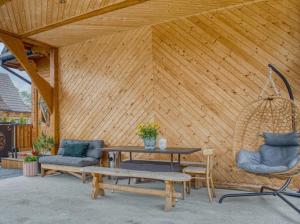 a patio with a table and chairs and a wooden wall at Apartamenty Bąkowo Chatka in Witów