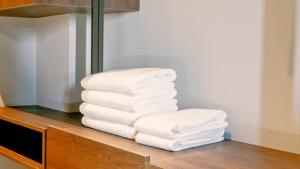 a stack of white towels sitting on a shelf at Eden Hotel in Rrogozhinë +103 photos