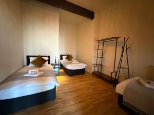 two beds in a room with wooden floors at The Holyrood Mega-Quarters in Edinburgh +5 photos
