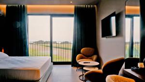 a hotel room with a bed and two chairs and a window at Eden Hotel in Rrogozhinë