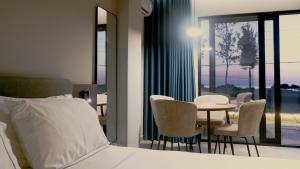 a bedroom with a bed and a table and chairs at Eden Hotel in Rrogozhinë