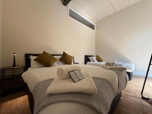 a bedroom with two beds with towels on them at The Holyrood Mega-Quarters in Edinburgh