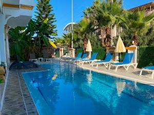 a pool at a resort with chairs and umbrellas at dolunaydın hotel in Side