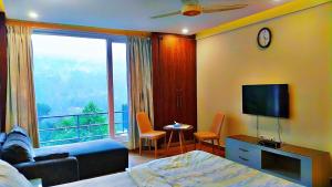 a hotel room with a bed and a large window at Luxe Villa in Murree